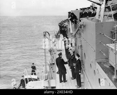 König Georg VI., in der Uniform der Flotte, traf den Kommandanten der HMS Scylla während eines viertägigen Besuchs der Heimatflotte in Scapa Flow. Stockfoto