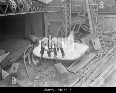 MÄNNER UND FRAUEN HINTER GROSSBRITANNIENS SCHIFFEN. MAI 1945, YARGARS MARINESCHIFT, GLASGOW. - Männer bohren auf einem Ruder Yarrow & Company Limited, Glasgow, Schiffbauer Stockfoto