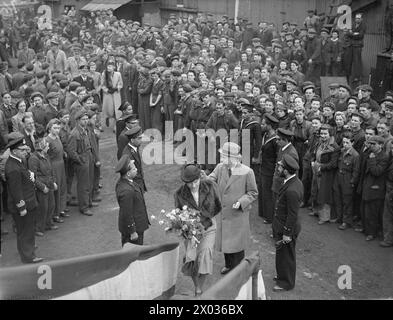 NEUE SCHALUPPE FÜR DIE ROYAL INDIAN NAVY AUF DER CLYDE BANK. 22. APRIL 1943, YARROWS YARD, CLYDEBANK, DER START EINER NEUEN SCHALUPPE FÜR DIE ROYAL INDIAN NAVY, DIE ZEREMONIE WURDE VON MRS. GODFREY, EHEFRAU VON VIZEADMIRAL V H GODFREY, CB, DURCHGEFÜHRT. Mrs. Godfrey nähert sich dem Bahnsteig durch die Reihen indischer Kleinoffiziere und Männer Stockfoto