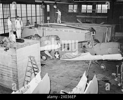 US-FLUGZEUGE FÜR DEN LUFTWAFFENARM DER BRITISCHEN FLOTTE. OKTOBER 1943, ROOSEVELT FIELD, LONG ISLAND, NEW YORK. DIE FLOTTENFLOTTE DER ROYAL NAVY SETZT DIE NEUESTEN FLUGZEUGTYPEN EIN, DIE IN DEN USA GEBAUT WURDEN. EINIGE DER FLUGZEUGE, DIE SICH IN DER PRÜFUNG, VERPACKUNG UND VERSAND AUS DEN USA BEFINDEN. - American Curtiss 'Seamews' wird für den Versand verpackt Stockfoto