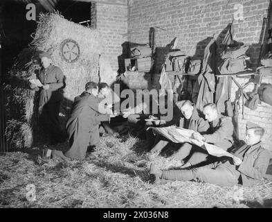 Britische Soldaten der britischen Expeditionstruppe in Frankreich im Jahr 1939 werden in einer französischen Scheune abgemauert und lesen abends. Stockfoto