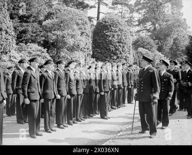 DER FÜNFTE SEE INSPIZIERT MARINE-LUFTFAHRTAUSBILDER. 22. JUNI 1945: ROYAL MARINEFLUGSTRAINESTATION IN NEWCASTLE-UNDER-LYME. DER FÜNFTE SEA LORD, KONTERADMIRAL T H TROUBRIDGE, CB, DSO UND BAR, FÜHRTE EINE AUSUFERNDE INSPEKTION VON MARINEFLUGZEUGEN DURCH. - Konteradmiral Troubridge inspiziert die Ehrenwache der Marinelehrlinge Stockfoto