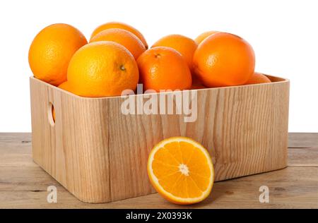 Frische Orangen in Kiste auf Holztisch vor weißem Hintergrund Stockfoto