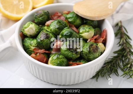 Köstliche geröstete Rosenkohl, Speck und Rosmarin auf dem Tisch, Nahaufnahme Stockfoto