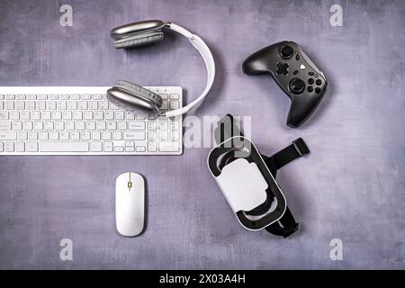 Gamepad, 3D-Brille, PC-Tastatur und Zubehör auf lila Oberfläche Stockfoto