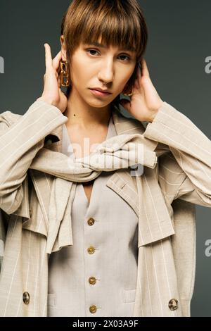 Eine junge Frau in einem Studio-Setting, die einen stylischen Schal um den Hals trägt, der Anmut und Schönheit ausstrahlt. Stockfoto