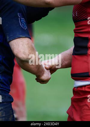 Nahaufnahme von zwei männlichen Rugby Union Spielern, die nach dem Spiel die Hand schütteln und Sportsmanship, Fairness UK zeigen Stockfoto