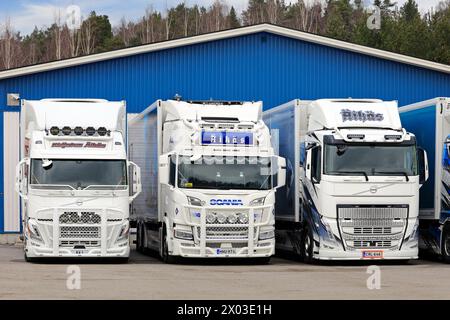 Drei neue, wunderschön angepasste Volvo und Scania Lkw parkten an einem Frühlingstag nebeneinander auf einem Hof. Salo, Finnland. 31. März 2024. Stockfoto