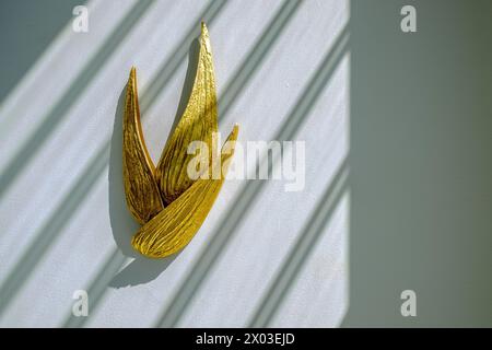 HAMALA, BAHRAIN - 2. MÄRZ 2019: Eine goldene Wandleuchte, beleuchtet durch Sonnenlicht, in einem Innenblick auf den Eingang einer luxuriösen Villa im Nahen Osten. Stockfoto