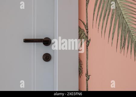 HAMALA, BAHRAIN - 2. MÄRZ 2019: Detailansicht des Türgriffs des Schlafzimmers mit maßgeschneiderter rosafarbener Tapete in einer luxuriösen Villa im Nahen Osten. Stockfoto