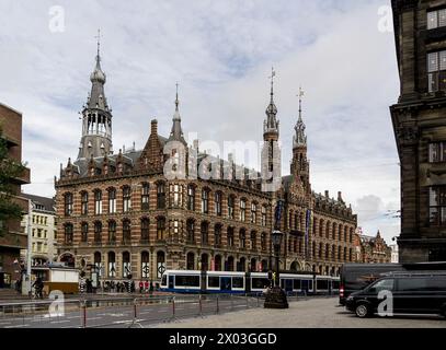 AMSTERDAM, NIEDERLANDE - 7. NOVEMBER 2013: Berühmtes Magna Plaza Einkaufszentrum in den Niederlanden mit einer blauen Straßenbahn davor Stockfoto