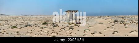 Anorama verlassener Toiletten in der Wüste, mit einem Meer von Sand um sie herum, bei Bogenfels Mine, draußen in der verlassenen Verbotszone Namibias. Stockfoto