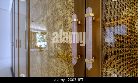 HAMALA, BAHRAIN - 2. MÄRZ 2019: Griffe aus rosa Onyx zieren einen Satz Glas- und Goldschränke in einer luxuriösen Villa im Nahen Osten. Stockfoto