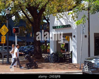 Miami, Florida, Vereinigte Staaten - 6. April 2024: Leute gehen an einem Starbuck Cafe in Coconut Grove vorbei. Stockfoto