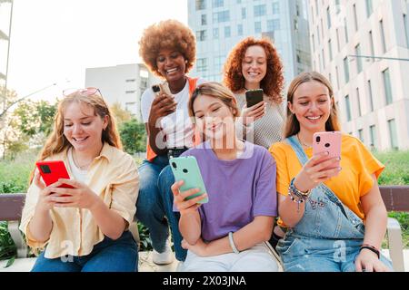 Nur Frauen, die Spaß mit ihren Handys haben. Frauen, die draußen sitzen und mit einer Smartphone-App im Internet surfen. Mädchen, die bei einem Meeting mit einem Handy die sozialen Medien sehen. Hochwertige Fotos Stockfoto