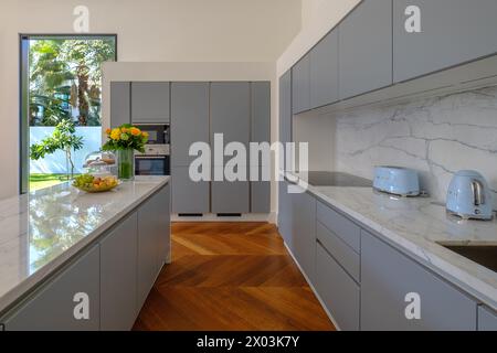 HAMALA, BAHRAIN - 2. MÄRZ 2019: Elegante moderne Küche mit Holzboden in einer Luxusvilla. Stockfoto