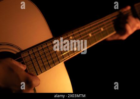 Die Hände des Mannes spielen Akustikgitarre. Musikhintergrund Stockfoto