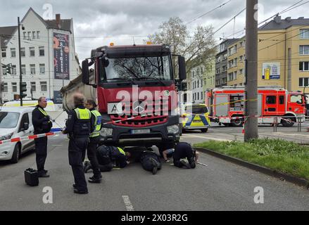 Köln, Deutschland. April 2024. Polizisten sind am Tatort im Einsatz, nachdem ein Radfahrer bei einem Unfall mit einem LKW ums Leben gekommen ist. Nach Angaben der Polizei biegt der 52-jährige LKW-Fahrer im Stadtteil Sülz rechts ab, als die Frau aus bisher ungeklärten Gründen unter den linken Hinterreifen des LKW fiel. Die Frau starb an ihren Verletzungen am Tatort. Quelle: Sascha Thelen/dpa - ACHTUNG: Kennzeichen und Transportunternehmen aus rechtlichen Gründen pixeliert/dpa/Alamy Live News Stockfoto