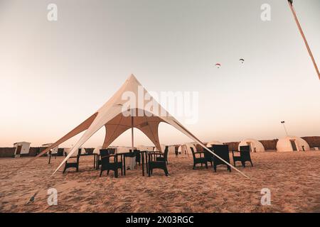 Zelte im QIA Wüstencamp am Binnenmeer im Persischen Golf bei Sonnenuntergang. Naher Osten, Arabische Halbinsel. Das Binnenmeer ist ein wichtiges Touristenziel Stockfoto