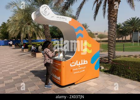 Frau, die eine Flasche in der Trinkwasserstation in Dubai, Vereinigte Arabische Emirate, füllt. Stockfoto