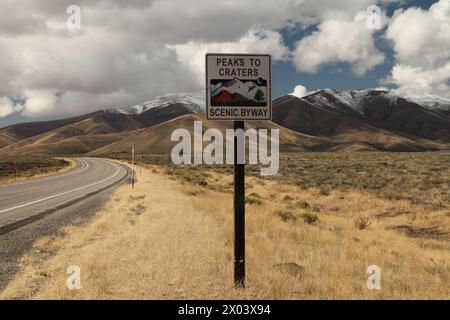 Schilder für Peaks to Craters Scenic Byway entlang des Highway im Craters of the Moon National Monument and Preserve, Idaho Stockfoto