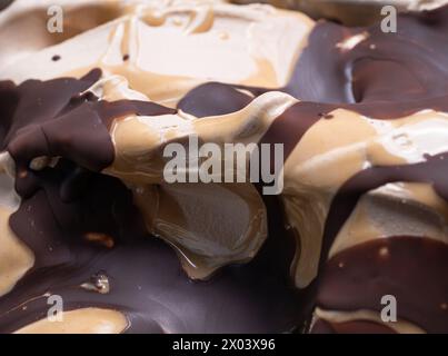 Frozen Toffifee Flavour Gelato - Vollformat Detail. Nahaufnahme von beige cremiger Oberflächenstruktur von Eiscreme, bedeckt mit Karamell- und Schokoladenüberzug. Stockfoto