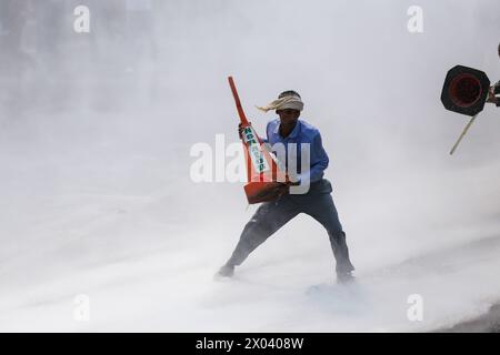 Monarchisten stoßen auf Polizei in Nepal Ein nepalesischer Pro-Monarchie-Demonstrant fällt auf den Boden, nachdem er mit strömendem Wasser getroffen wurde, das aus der Wasserkanone der nepalesischen Polizei geschossen wurde, während sie nach einem Sicherheitsbruch zusammenstoßen, der es den Demonstranten erlaubte, in das Sperrgebiet nahe Singha Durbar zu gelangen. Verwaltungshauptstadt der Himalaya-Nation am 9. April 2024. Tausende pro-monarchistische Kader und Kader der RPP der Rastriya Prajatantra-Partei schlugen die Straße von Kathmandu ein und stießen mit Sicherheitspersonal zusammen, während sie versuchten, in das Sperrgebiet einzubrechen. RPP, eine rechte Pro-Monarchen-Partei führt an Stockfoto