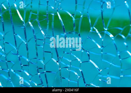 Risse auf blauem Glas, Nahaufnahme. Hintergründe und Texturen. Glasbruch, Zerstörung. Stockfoto