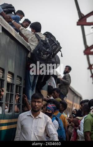 Dhaka, Bangladesch. April 2024. Die Leute klettern auf das Dach des Zuges am Bahnhof Tongi. Die Menschen reisen nach Hause, um das Eid al-Fitr-Festival zu feiern, das das Ende des Heiligen Fastenmonats des Islam im Ramadan markiert. Quelle: SOPA Images Limited/Alamy Live News Stockfoto