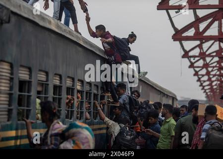 Dhaka, Bangladesch. April 2024. Die Leute klettern auf das Dach des Zuges am Bahnhof Tongi. Die Menschen reisen nach Hause, um das Eid al-Fitr-Festival zu feiern, das das Ende des Heiligen Fastenmonats des Islam im Ramadan markiert. (Foto: Sazzad Hossain/SOPA Images/SIPA USA) Credit: SIPA USA/Alamy Live News Stockfoto