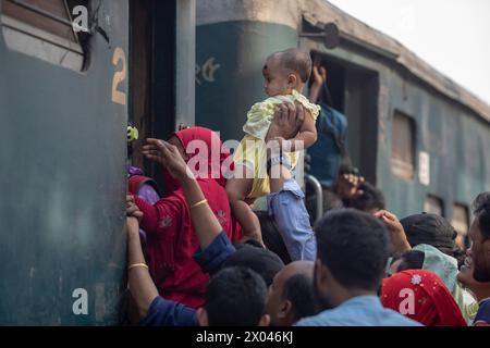 Dhaka, Bangladesch. April 2024. Eine Frau mit einem Kind versucht, in den Zug am Bahnhof Tongi zu steigen. Die Menschen reisen nach Hause, um das Eid al-Fitr-Festival zu feiern, das das Ende des Heiligen Fastenmonats des Islam im Ramadan markiert. (Foto: Sazzad Hossain/SOPA Images/SIPA USA) Credit: SIPA USA/Alamy Live News Stockfoto