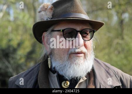 Älterer deutscher Mann von siebzig Jahren mit Sonnenbrille, Bart und grünem Hut, eine Fedora mit einem kleinen Gamsbart Stockfoto