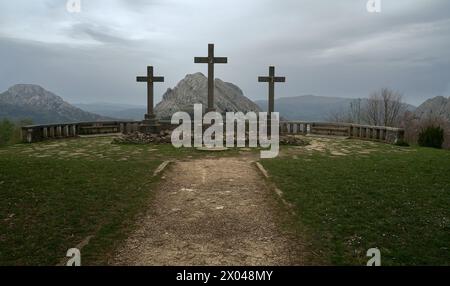 Foto einer religiösen Skulptur, in der drei große Kreuze in einem Aussichtspunkt zu sehen sind, und im Hintergrund sehen Sie einige Berge, alle umgeben von B Stockfoto