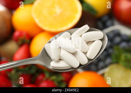 Vitaminpillen im Löffel über frischem Obst, Nahaufnahme Stockfoto