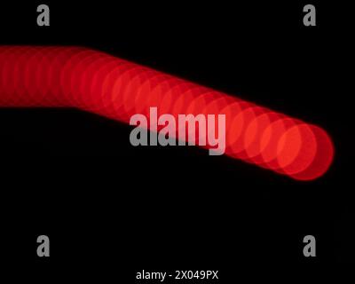 Abstraktes rotes Bokeh auf schwarzem Hintergrund, unscharfe Lichter Hintergrund Stockfoto