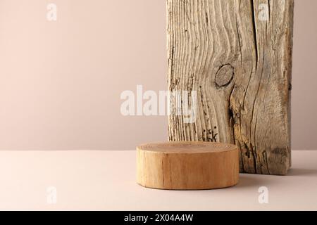 Präsentation für das Produkt. Hölzerne Podium auf beigefarbenem Hintergrund. Leerzeichen für Text Stockfoto