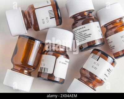 Gebrauchte Pillenflaschen aus Glas auf weißer Oberfläche Stockfoto