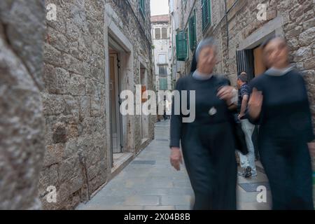 Split Kroatien - 26. Mai 2011: Menschen und zwei Nonnen verschwimmen in Bewegung, als sie in einer engen Gasse in der historischen europäischen Stadt auf die Kamera zuliefen Stockfoto