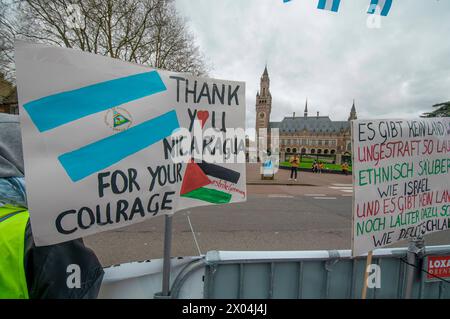 Plakate auf dem Carnegieplein, mit dem (ICJ) im Fernverkehr, während der heutigen Verhandlung des Internationalen Gerichtshofs (ICJ), der Fall Nicaraguas gegen Eine kleine Gruppe, die etwas größer als gestern war, aus palästinensischen und nicaraguanischen Unterstützern bestand, heute Morgen wurde das Holocaust-Denkmal vor dem Internationalen Gerichtshof (ICJ) in den Haag bei der zweiten zweitägigen Verhandlung versammelt. Der Fall wurde von Nicaragua gegen Deutschland erhoben. Deutschland hat gesagt, Israels Sicherheit sei der "Kern" seiner Außenpolitik, da es einen Völkermordfall verteidigt, der vor dem UN-Gericht gegen Israel erhoben wird Stockfoto