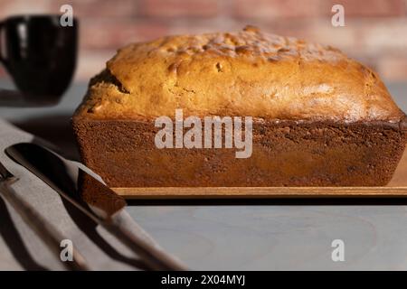 Bananenbrot, gebacken zu einer goldenen Kruste und auf ein Holzblech gelegt Stockfoto