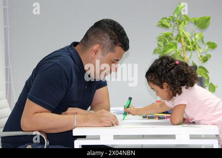 3-jähriges Mädchen nimmt Therapie mit einem Psychologen in seiner Praxis, spielt und zeichnet als Spieltherapie zur Behandlung von Autismus und ADHS Stockfoto