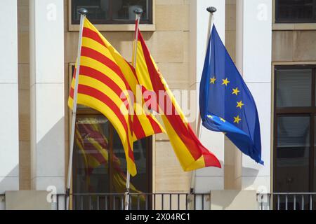 Lebhafte spanische, katalanische und europäische Flaggen flattern zusammen, ihre Farben zeugen von der reichen kulturellen Wandteppiche und der gemeinsamen Geschichte. Stockfoto