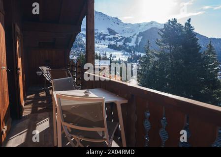 Holzbalkon mit Blick auf die schneebedeckten Berge im alpinen Dorf Stockfoto