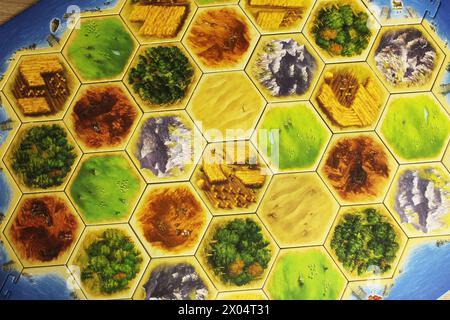 Mozyr, Weißrussland, 1. April 2024: Ein catan-Brettspiel mit gelben und weißen Spielerfiguren. Familienzeit. Tag Der Brettspiele. Stockfoto