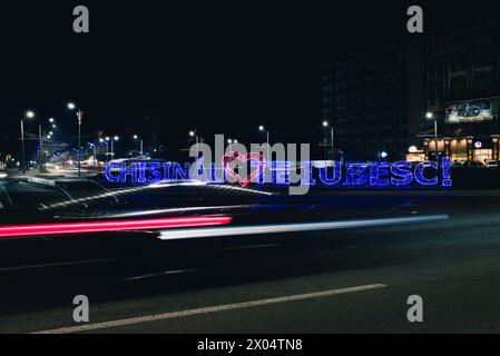 Chisinau liebt Sie, mit einem roten Herzen in der Mitte, geschrieben in Buchstaben des Lichts, Nachtbeleuchtung an einem Kreisverkehr am Eingang der Stadt. Stockfoto