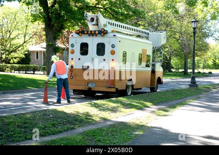 Lackierwagen mit einem Kirschpflücker oben für Arbeiten auf höheren Ebenen. Mann, der Sicherheitskegel für den Stapler aufstellt. St. Paul Minnesota MN USA Stockfoto