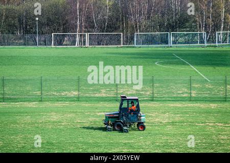 Rasenmäher, der auf einem Fußballfeld Gras schneidet Stockfoto