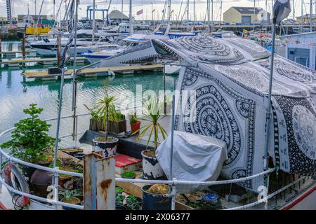 Nahaufnahme eines Bootes im Ramsgate Royal Harbour mit Topfpflanzen und dekorativen schwarz-weißen Stoffen. Stockfoto