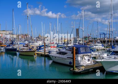 Ramsgate Royal Harbour voller verschiedener Boote und Yachten, unter einem blauen Himmel mit flauschigen weißen Wolken. Stockfoto