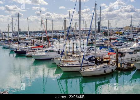 Ramsgate Royal Harbour voller verschiedener Boote und Yachten, unter einem blauen Himmel mit flauschigen weißen Wolken. Stockfoto